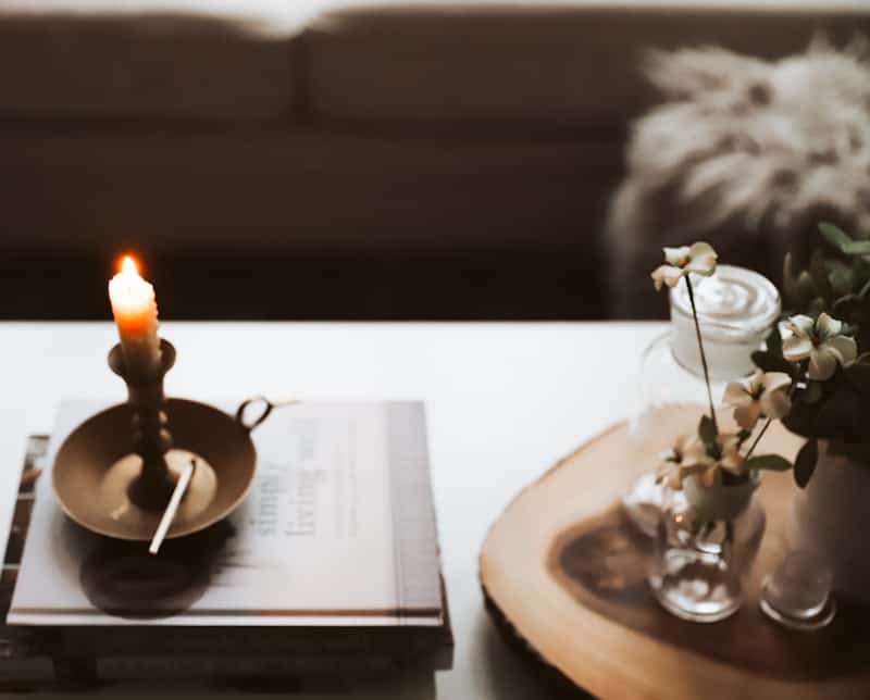candle on top of book with a wooden match