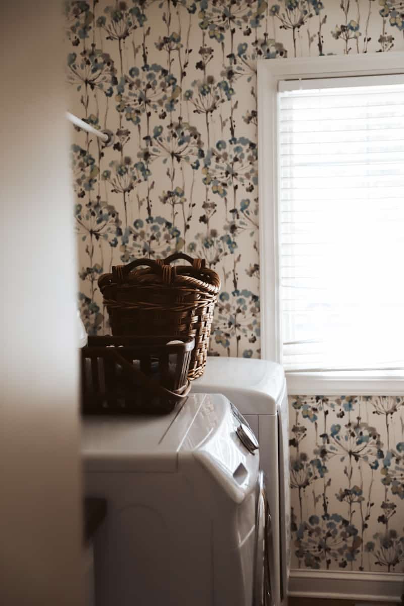 a laundry room with floral wallpaper