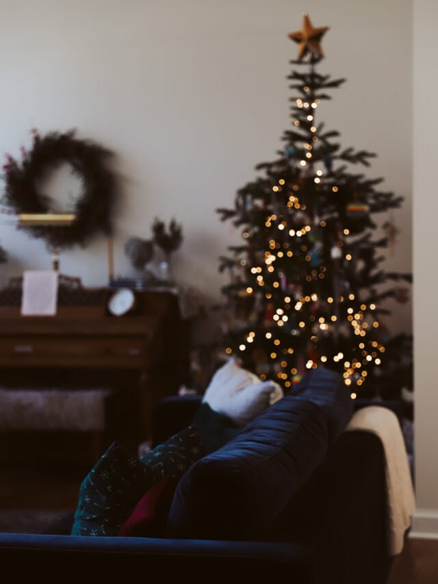 sparkly christmas tree in living room with a blue sofa