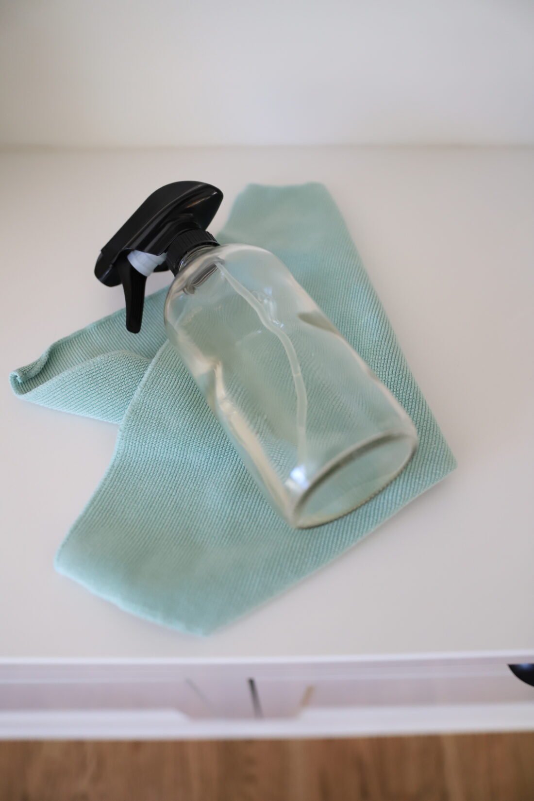 spray bottle and rag on a white counter top