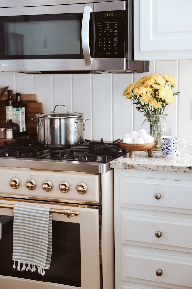 gas range in a white kitchen with eggs in a wooden bowl