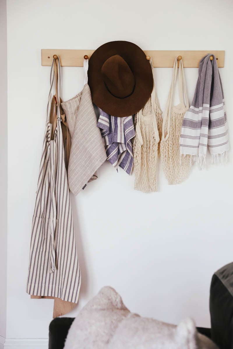 a peg rack with towels and kitchen aprons hanging on it