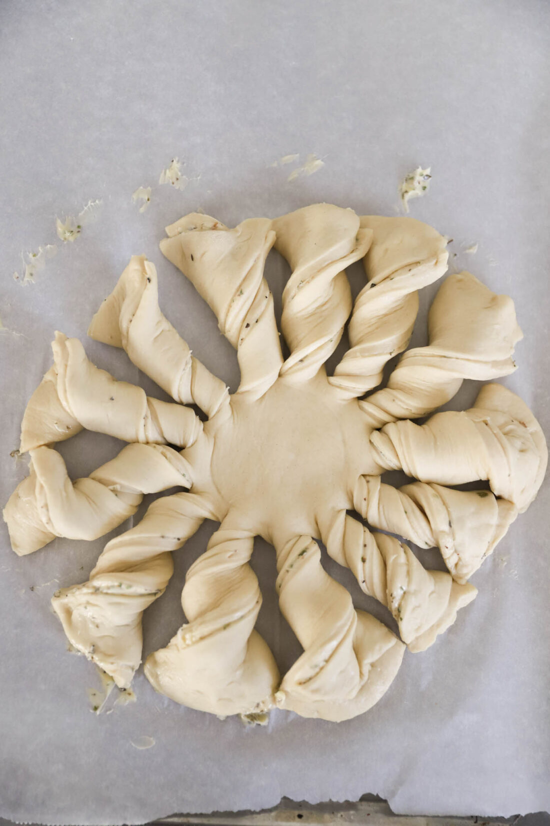 unbaked pizza dough twisted in a wreath.