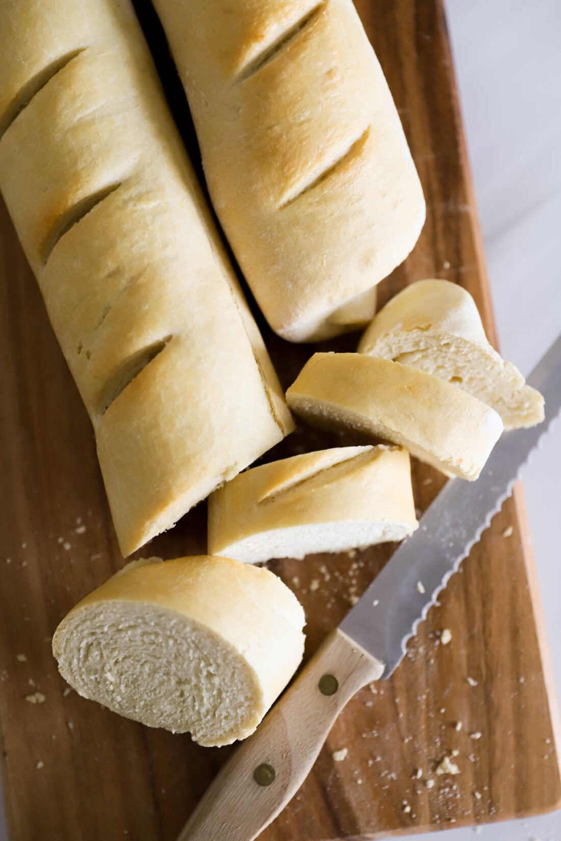 Loaves of french bread sliced on a cutting board.