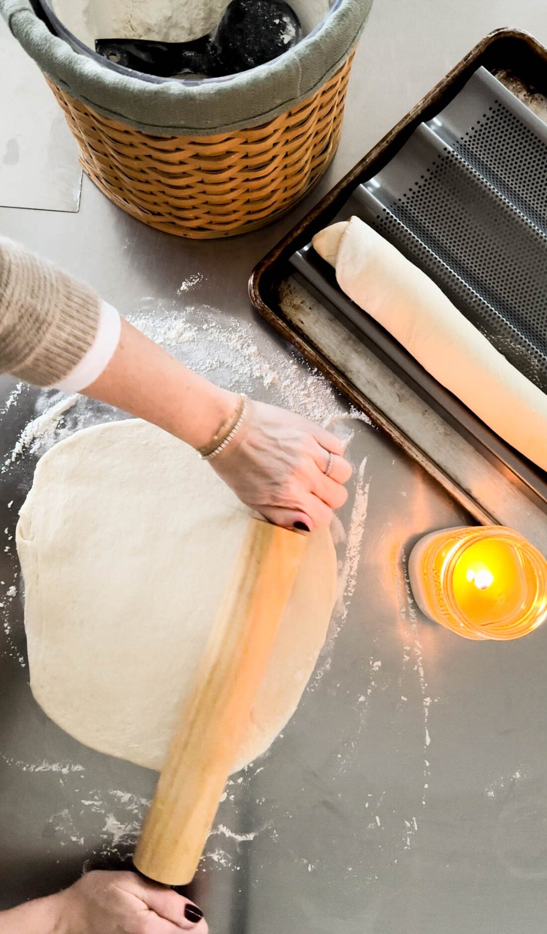 Hands rolling out bread dough.