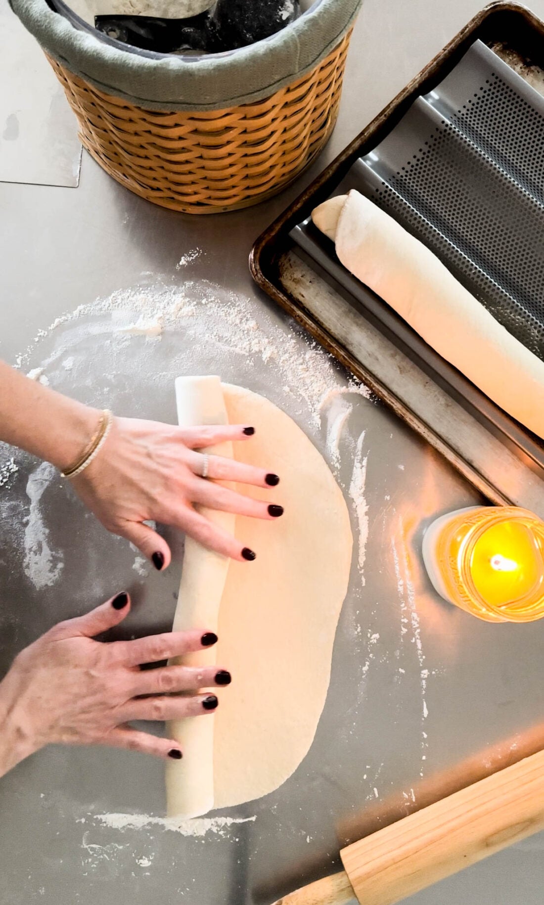 Hands rolling out bread dough.