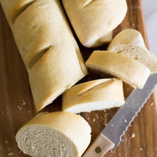 Loaves of french bread sliced on a cutting board.