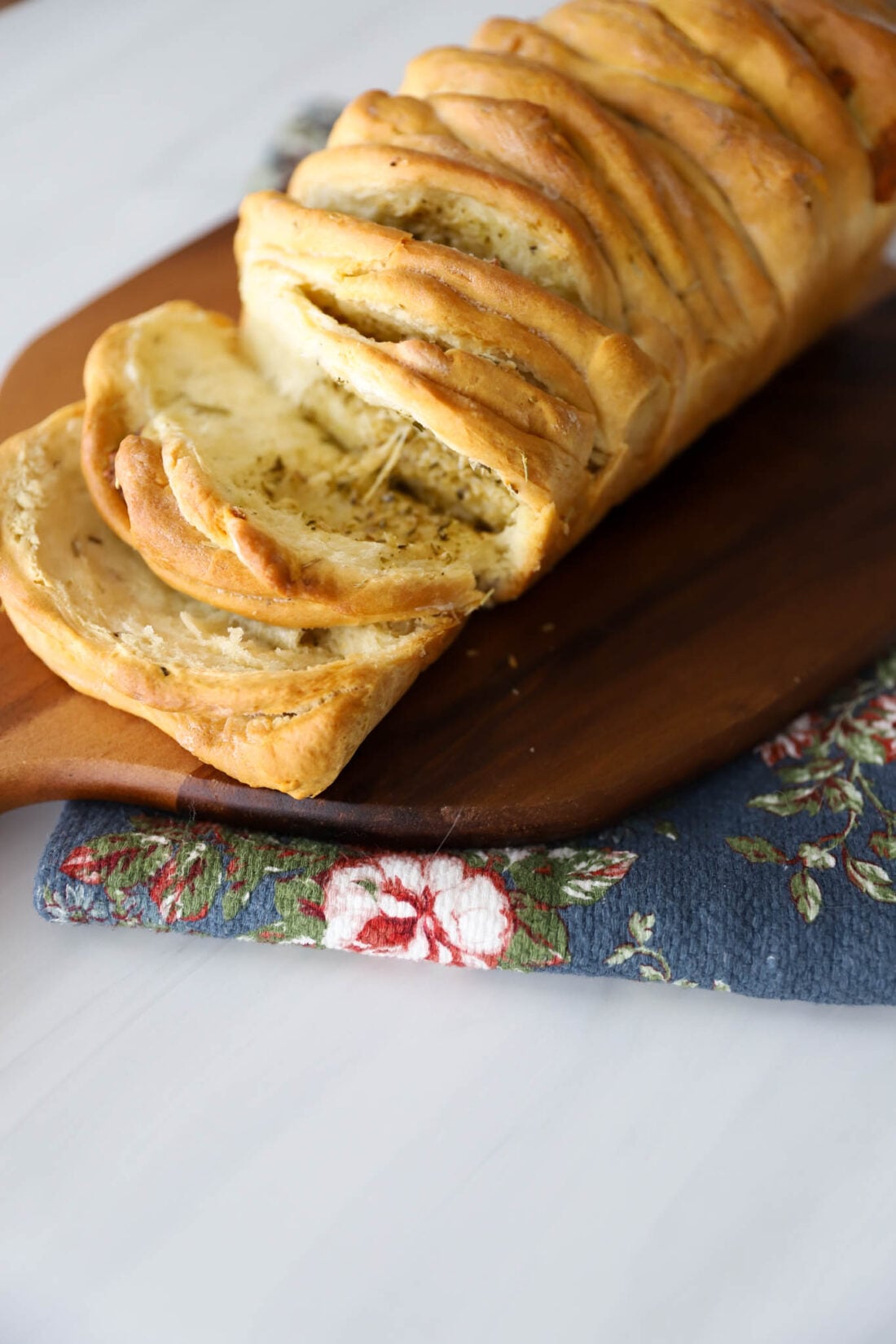 Rosemary pull apart bread on a cutting board.