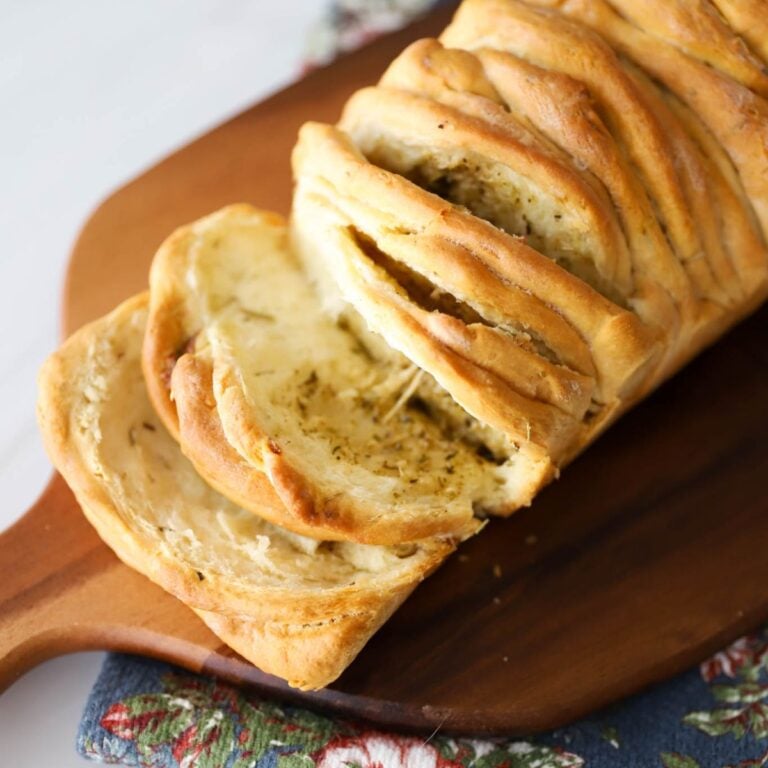 Rosemary pull apart bread on a cutting board.