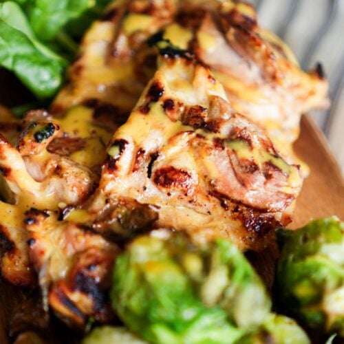 Delicious honey mustard chicken thighs on a cutting board.