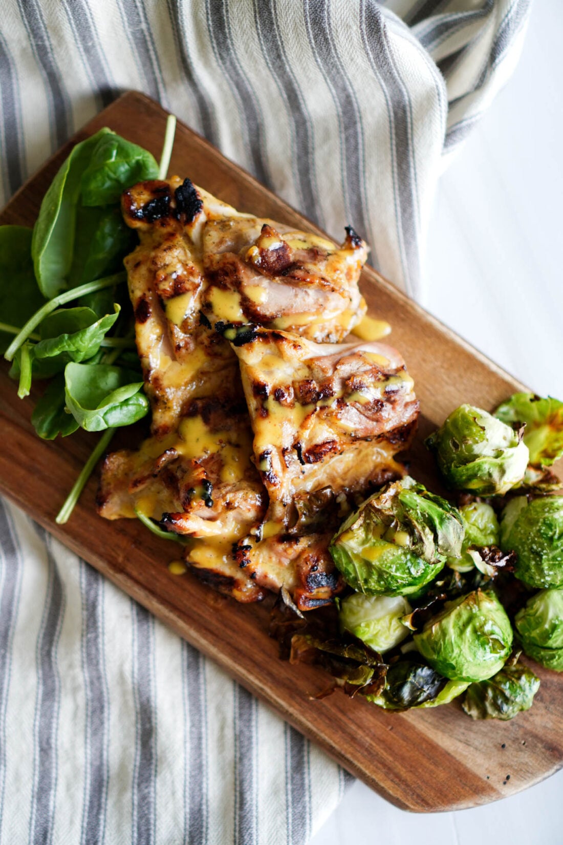 Delicious honey mustard chicken thighs on a cutting board.
