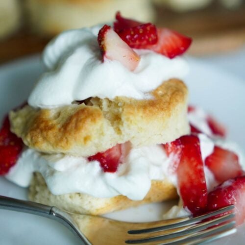 Strawberry shortcake on a white plate with a fork.